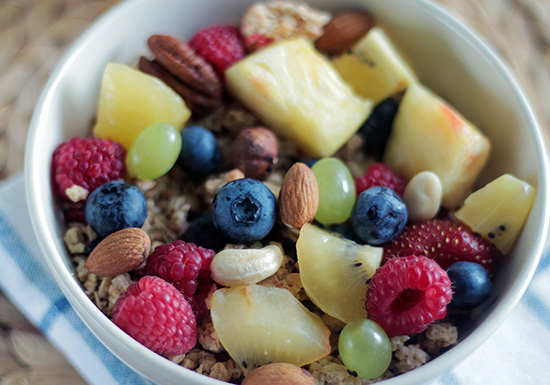 Ciotola con frutti di bosco freschi e frutta secca, ricchi fonti naturali di vitamine, minerali e antiossidanti essenziali per l'organismo.
